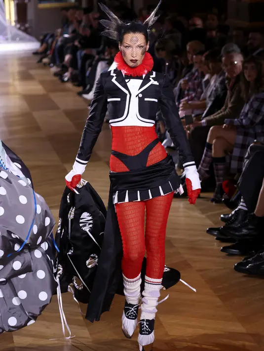<p>Bella Hadid mempersembahkan kreasi Thom Browne saat peragaan busana Musim Semi-Musim Panas 2023 sebagai bagian dari Paris Womenswear Fashion Week, Paris, Prancis, 3 Oktober 2022. Model berusia 25 tahun ini tampak luar biasa dalam balutan busana merah, hitam, dan putih yang terinspirasi dari adibusana kartun. (Photo by Vianney Le Caer/Invision/AP)</p>