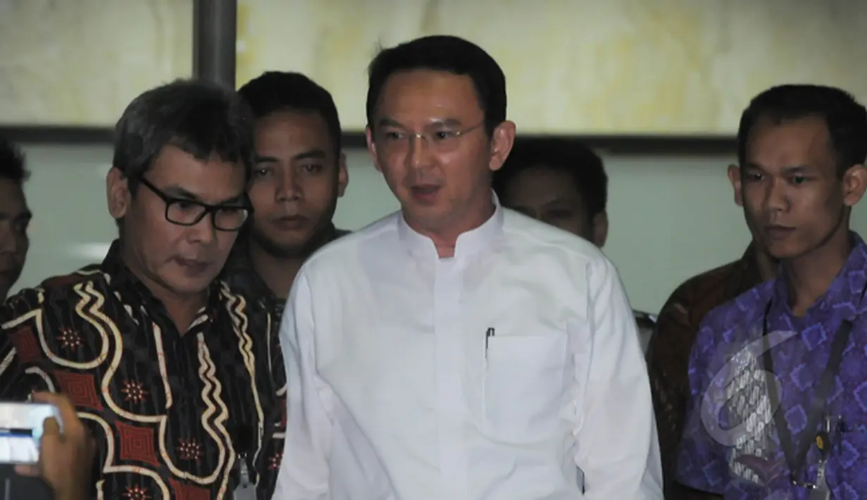 Ahok ditemani Johan Budi keluar gedung KPK usai melaporkan hasil temuannya, Jakarta, Jumat (27/2/2015). Kedatangan Ahok untuk melaporkan temuan dana siluman di Pemerintah Provinsi DKI. (Liputan6.com/Herman Zakharia)