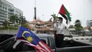Warga Muslim membawa bendera Palestina saat konvoi protes menentang serangan Israel di Gaza di luar Kedutaan Besar Amerika Serikat di Kuala Lumpur, Malaysia, Jumat (21/5/2021).  (AP Photo / Vincent Thian)