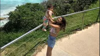 Acha Septriasa berpose dengan latar Pantai Bondi Australia saat memomong sang putri. (dok. Instagram @septriasaacha/Dinny Mutiah)
