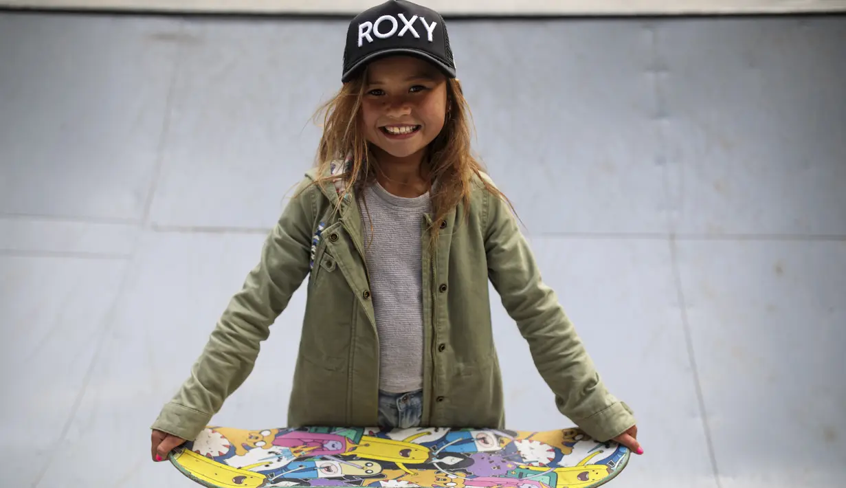 Sky Brown berpose sambil memegang skateboardnya di sebuah taman di kota Kijo, prefektur Miyazaki, Jepang (14/1). Sky pernah menjadi atlet olahraga skateboard profesional termuda di kejuaraan X Games Vans Pro Skate Series 2016. (AFP/Behrouz Mehri)