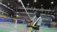 Pekerja sedang memasang net bulutangkis di Muntinlupa Sports Center menjelang SEA Games 2019, Sabtu (23/11/2019). (Bola.com/Muhammad Iqbal Ichsan)