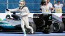 Pembalap tim Mercedes, Lewis Hamilton berlari setelah menyelesaikan balapan F1 Grand Prix Meksiko di Sirkuit Autodromo Hermanos Rodriguez, Meksiko (30/10). (Reuters/Henry Romero)