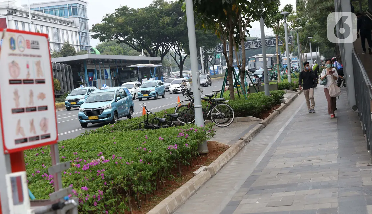 Warga menggunakan masker berjalan di pedestrian kawasan Jalan Jenderal Sudirman, Jakarta, Kamis (10/9/2020). Setelah mempertimbangkan sejumlah faktor, di antaranya ketersediaan tempat tidur rumah sakit, PSBB DKI Jakarta kembali diperketat per Senin (14/9). (Liputan6.com/Helmi Fithriansyah)