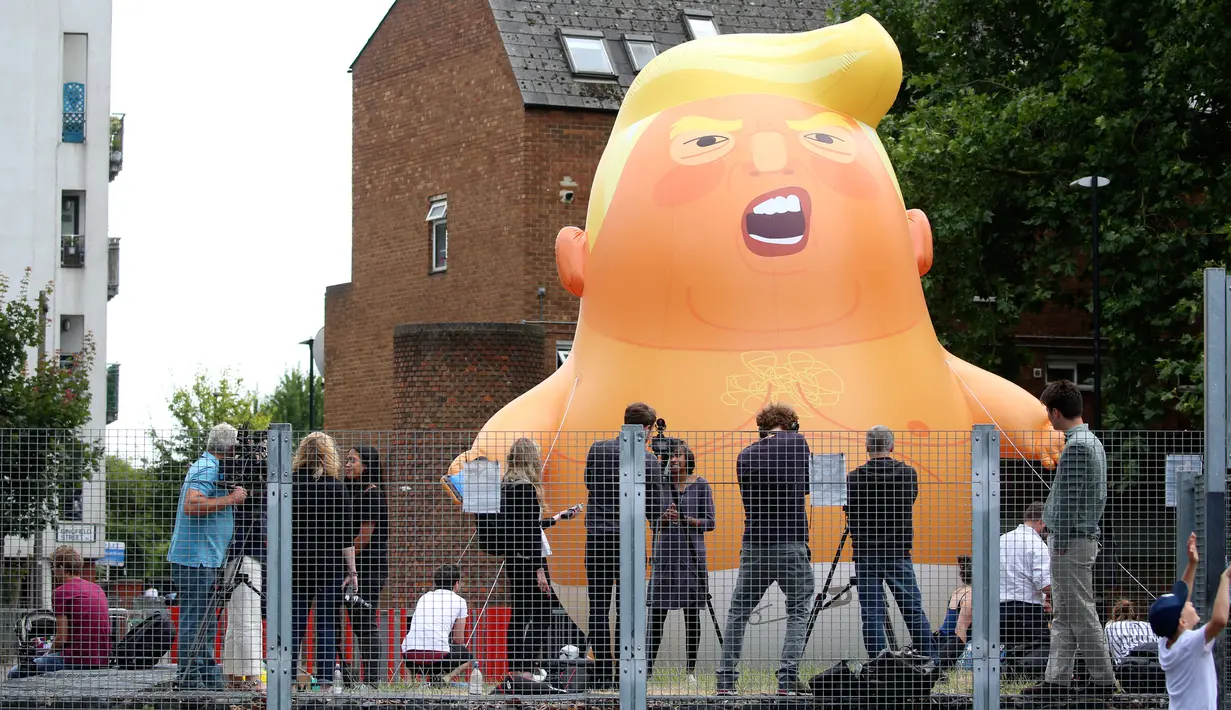 Aktivis mengembangkan balon bayi Presiden AS Donald Trump di London, 10 Juli 2018. Kemunculan balon berpopok itu mungkin bisa memperburuk ketegangan antara Wali Kota Sadiq Khan dan Trump, yang sebelumnya saling cibir di Twitter. (AFP/Isabel INFANTES)