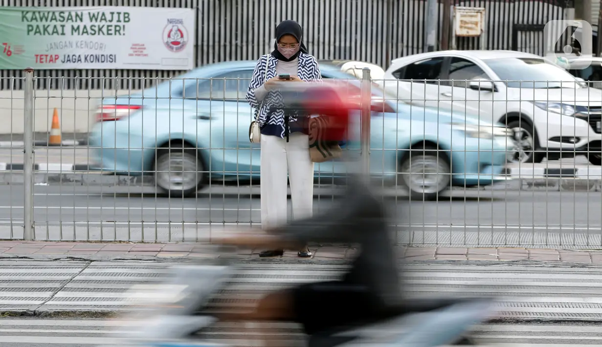 Pejalan kaki menanti waktu menyebrang di Jalan Jenderal Sudirman, Jakarta, Minggu (21/11/2021). Untuk mencegah lonjakan kasus Covid-19, pemerintah akan menerapkan kebijakan PPKM Level 3 untuk seluruh wilayah Indonesia selama masa libur Natal 2021 dan Tahun Baru 2022.(Liputan6.com/Helmi Fithriansyah)
