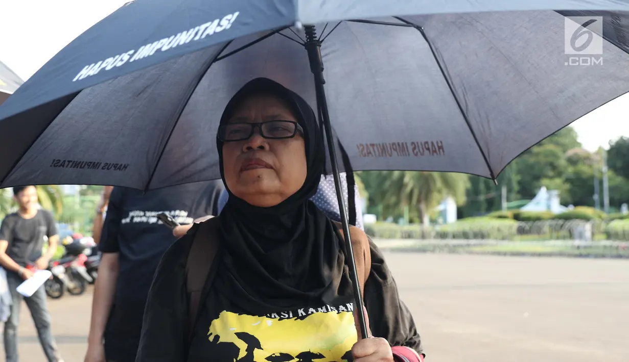 Ibu Ati, salah satu korban penggusuran Teluk Gong 2001 saat aksi Kamisan di depan Istana Negara, Jakarta, Kamis (14/2). Lewat aksi Kamisan, JSKK meminta komitmen pemerintah menyelesaikan kasus pelanggaran HAM masa lalu. (Liputan6.com/Helmi Fithriansyah)