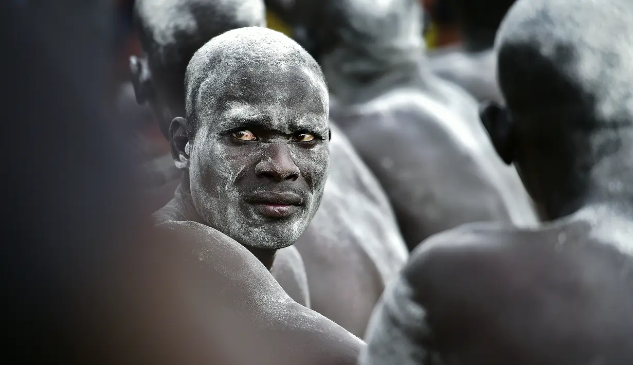 Peserta gulat mewarnai tubuhnya dengan bubuk putih  dalam Kompetisi Gulat Nasional Sudan Selatan di Stadion Juba, Sudan (20/4). Kompetisi gulat ini diselenggarakan dalam rangka untuk perdamaian. (CARL DE SOUZA / AFP)