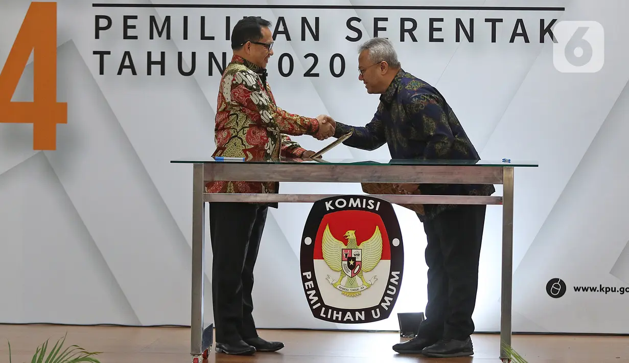 Mendagri, Tito Karnavian (kiri) dan Ketua KPU Arief Budiman saat Serah Terima Data Penduduk Potensial Pemilih Pemilihan (DP4) untuk Pemilihan Serentak 2020 di Jakarta, Kamis (23/1/2020). Kemendagri menyerahkan DP4 dengan jumlah 105 juta. (Liputan6.com/Herman Zakharia)