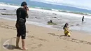 Warga mengabadikan gambar di pinggir Pantai Karang Hawu, Sukabumi, Jawa Barat, (8/2). Mengisi libur Imlek, Sejumlah wisatawan mengunjungi Pantai Karang Hawu. (Liputan6.com/Immanuel Antonius)