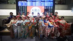 Sejumlah wanita berbaju Kimono berpose depan papan harga saham saat pembukaan Bursa Efek Tokyo di Tokyo, Jepang, Jumat (4/1). Sederet gadis cantik berpakaian Kimono turut hadir meramaikan acara tersebut. (AP Photo/Eugene Hoshiko)