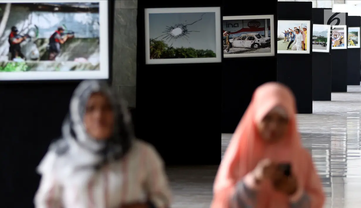 Pengunjung melihat foto-foto peristiwa Reformasi 1998 yang dipamerkan di Gedung Nusantara III, Jakarta, Jumat (11/5). Pameran ini bertajuk "20 Tahun Reformasi: Kembali ke Rumah Rakyat”. (Liputan6.com/JohanTallo)