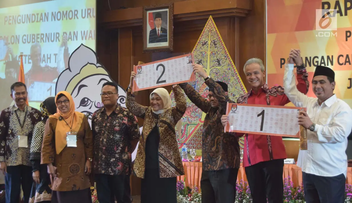 Pasangan calon gubernur Ganjar Pranowo dan Taj Yasin serta Pasangan calon gubernur  Sudirman Said dan Ida Fauziah menunjukkan nomor urut undian calon Gubernur dan Wakil Gubernur Jawa Tengah , Selasa (13/2) malam. (Liputan6.com/Gholib)