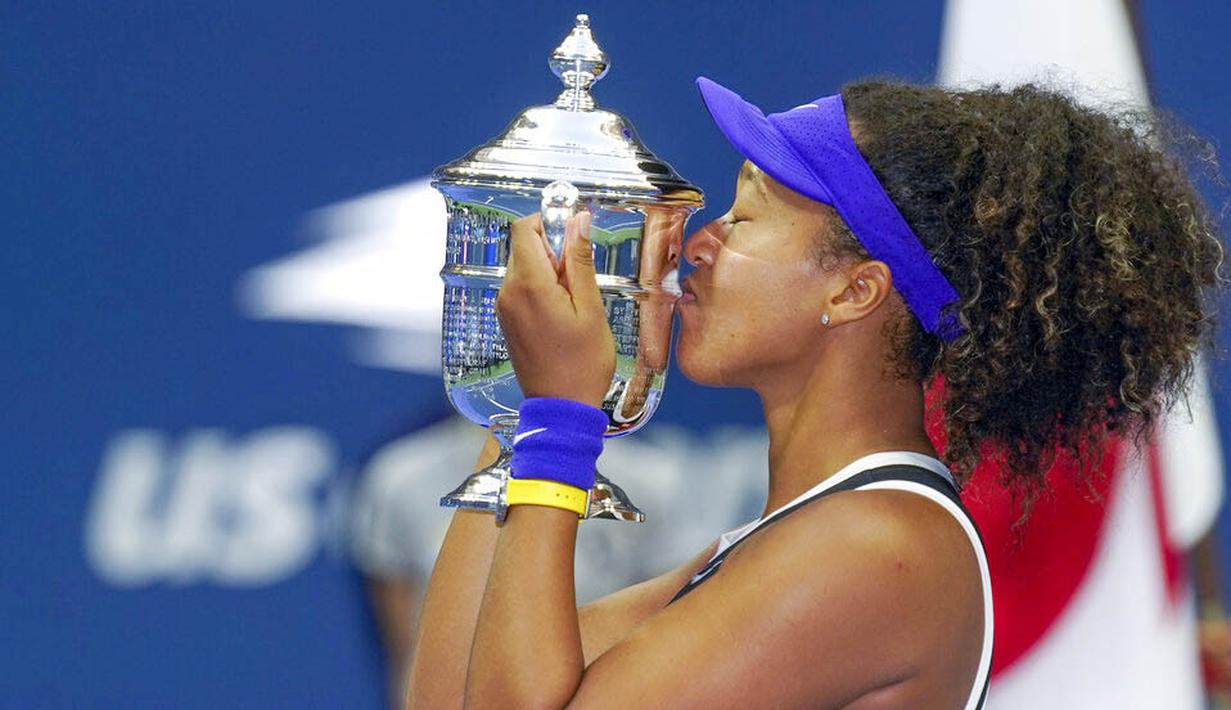 Petenis Jepang, Naomi Osaka, mencium trofi usai menjuarai AS Terbuka di Arthur Ashe Stadium, New York, Minggu (13/9/2020). Naomi Osaka mengalahkan Victoria Azarenka 1-6, 6-3, dan 6-3. (AP Photo/Seth Wenig)