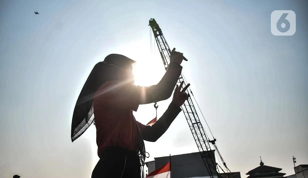 Dirigen saat memandu peserta upacara menyanyikan lagu Indonesia Raya. dalam upacara memperingati Hari Kemerdekaan ke-76 RI di Cilincing, Jakarta, Selasa (17/8/2021). (merdeka.com/Iqbal S. Nugroho)