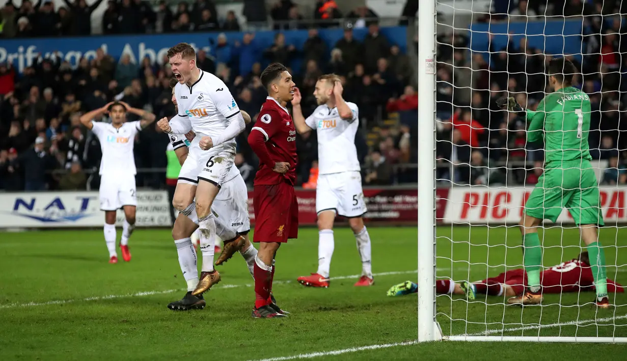 Pemain Swansea City, Alfie Mawson berselebrasi setelah mencetak gol ke gawang Liverpool dalam lanjutan Premier League di Stadion Liberty, Selasa (23/1). Swansea City menjadi penjegal Liverpool meneruskan rekor tanpa kalah. (Nick Potts/PA via AP)