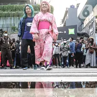 Evelyn Nada Anjani dan DJ nomor satu di Jepang, DJ Shacho berpose menampilkan busananya di atas zebra cross di kawasan Dukuh Atas, Jakarta, Selasa (26/7/2022). Evelyn dan DJ Shacho ikut meramaikan fenomena Citayam Fashion Week dengan tampil mengenakan busana khas negeri Sakura, Jepang. (Liputan6.com/Faizal Fanani)