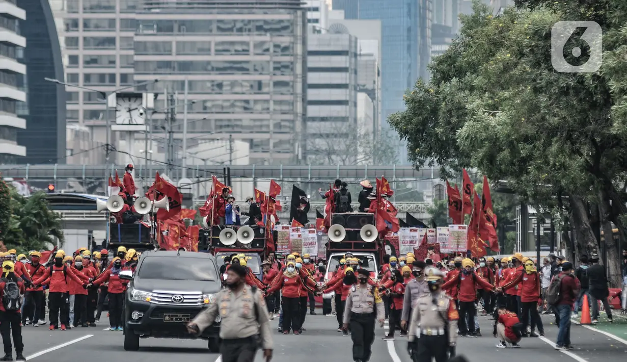 Massa buruh dari berbagai daerah menggelar longmarch saat unjuk rasa di kawasan Patung Kuda, Jakarta, Selasa (10/11/2020). Dalam aksinya massa buruh mendesak Presiden Jokowi untuk membatalkan UU Cipta Kerja. (merdeka.com/Iqbal S. Nugroho)