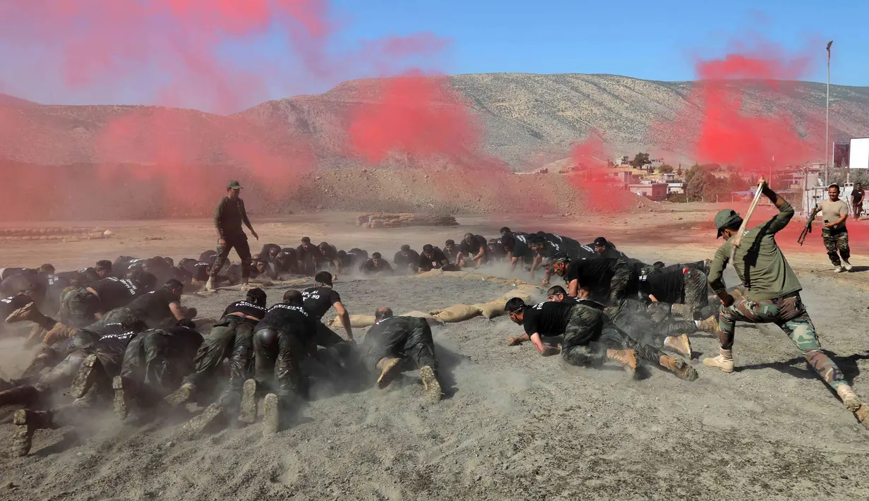 Para perwira Peshmerga melakukan latihan saat mengambil bagian dalam upacara kelulusan di Kota Soran, Irak, Rabu (16/10/2019). Latihan pasukan bersenjata Kurdi tersebut dilakukan sekitar 100 kilometer timur laut ibu kota otonomi wilayah Kurdi di Irak, Arbil. (SAFIN HAMED/AFP)