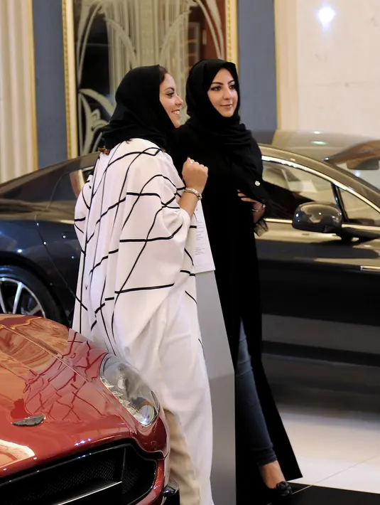 Dua wanita Saudi saat mengunjungi pameran mobil di resor Jeddah Laut Merah Jeddah (5/10). Pada bulan September 2017 Kerajaan Arab Saudi mengeluarkan dekrit yang memperbolehkan wanita untuk mengendarai mobil. (AFP Photo/Amer Hilabi)