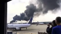 Warga mengabadikan pesawat American Airlines yang terbakar di Bandara O'Hare Chicago, Illinois, AS (28/10). Akibat kejadian tersebut Pilot pesawat dengan sigap segera membatalkan proses take-off. (Courtesy of Robocast.com/Handout via REUTERS)
