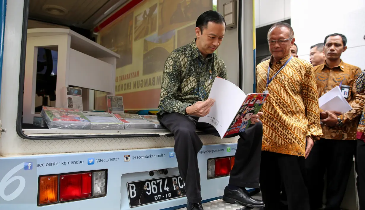 Mendag Thomas Lembong membaca di Mobile magic box saat peluncuran ASEAN Economic Community (AEC) Center di Kemendag, Jakarta, Senin (28/9/2015). AEC Center dibentuk untuk edukasi publik tentang perkembangan dan peluang MEA. (Liputan6.com/Faizal Fanani)