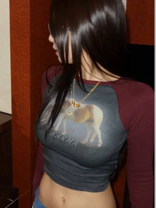 Jaket dipadukan dengan inner atasan long  sleeve crop warna maroon bergambar kuda. Serta mengenakan kalung layering emas. [@jennierubyjane]