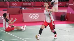 Pasangan Indonesia, Greysia Polii (kanan) dan Apriyani Rahayu merayakan kemenangannya setelah mengalahkan Chen Qing Chen dan Jia Yi Fan dari China pada pertandingan perebutan medali emas ganda putri pada Olimpiade Musim Panas 2020, Senin, 2 Agustus 2021, di Tokyo, Jepang. (AP Photo/Dita Alangkara)