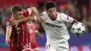 Gelandang Bayern Munchen Joshua Kimmich berebut bola dengan pemain Sevilla Joaquin Correa saat pertandingan Liga Champions di stadion Sanchez Pizjuan di Sevilla (3/4). (AFP Photo/Jorge Guerrero)