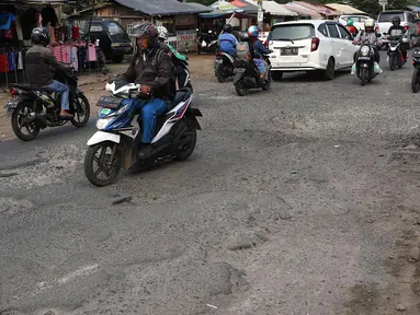 Lalu lalang kendaraan saat melintasi jalan berlubang di kawasan Gas Alam, Depok, Jawa Barat, Kamis (4/10). Jalan rusak di kawasan tersebut sudah berlangsung selama bertahun-tahun. (Liputan6.com/Immanuel Antonius)