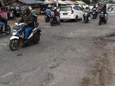 Lalu lalang kendaraan saat melintasi jalan berlubang di kawasan Gas Alam, Depok, Jawa Barat, Kamis (4/10). Jalan rusak di kawasan tersebut sudah berlangsung selama bertahun-tahun. (Liputan6.com/Immanuel Antonius)