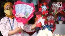 Penjual menujukkan bunga mawar yang dihias dengan boneka,uang dan coklat di Rawa Belong, Jakarta, Senin (14/2/2022). Hari Valentine yang diperingati setiap 14 Februari menjadi berkah bagi para penjual bunga karena banyak pesanan bunga di momen kasih sayang tersebut. (Liputan6.com/Angga Yuniar)