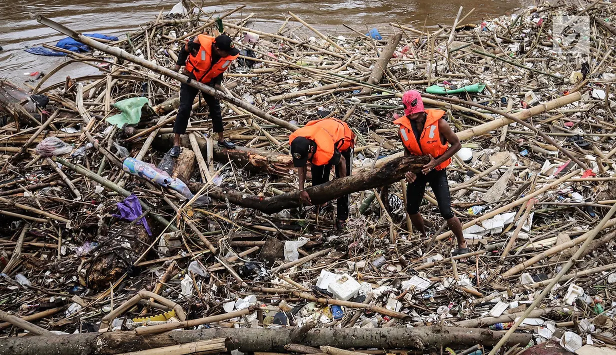 Petugas kebersihan betopeng Spiderman membersihkan sampah yang menumpuk di Pintu Air Manggarai, Jakarta, Senin (12/11). Sebagian besar sampah seperti, batang pohon, bambu, setereofoam, plastik hingga kasur. (Liputan6.com/Fery Pradolo)