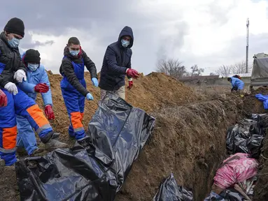 Jenazah ditempatkan pada kuburan massal di pinggiran Mariupol, Ukraina, 9 Maret 2022. Warga tidak dapat menguburkan orang mati di antara mereka karena serangan berat oleh pasukan Rusia. (AP Photo/Evgeniy Maloletka)