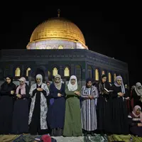 Muslim Palestina menjalani ibadah salat saat memburu malam Lailatul Qadar di luar Kubah Batu (Dome of the Rock) di kompleks Masjid Al-Aqsa di Yerusalem (8/5/2021). (AFP/Ahmad Gharabli)