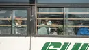 Warga negara India diangkut dengan bus keluar dari Bandara Internasional Indira Gandhi setelah dievakuasi dari kota Wuhan di China, di New Delhi (1/2/2020). India mengevakuasi sekitar 250 warganya dari Wuhan, kota di Hubei yang merupakan pusat wabah virus corona. (AFP/Money Sharma)