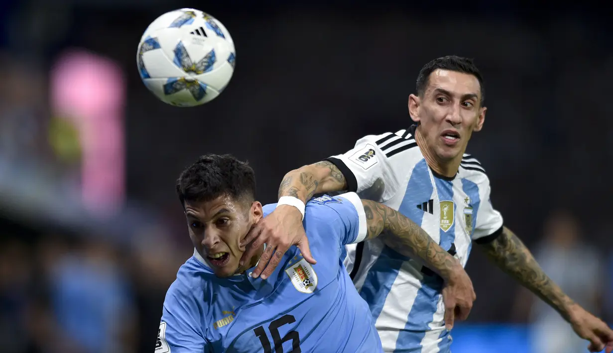 Bek Timnas Uruguay, Mathias Olivera (kiri) berebut bola dengan gelandang Timnas Argentina, Angel Di Maria pada laga lanjutan Kualifikasi Piala Dunia 2026 Zona Conmebol di La Bombonera Stadium, Buenos Aires, Argentina, Jumat (17/11/2023) pagi WIB. (AP Photo/Gustavo Garello)