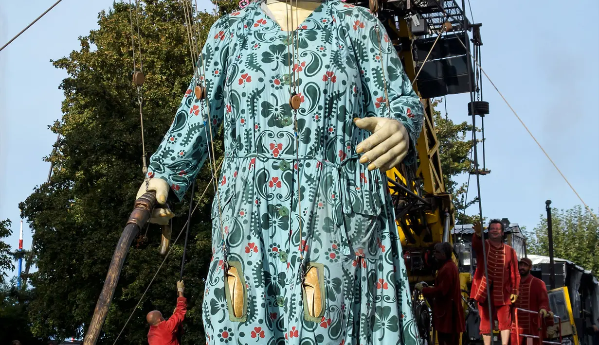 Sejumlah seniman mengarak boneka raksasa nenek-nenek setinggi 7,30 meter dengan alat berat di Jenewa, Swiss (1/10). Dalam pertunjukan The Saga of the Giants selama tiga hari, teater ini berhasil menarik ratusan ribu penonton. (AFP Photo/Fabrice Coffrini)