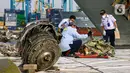 Petugas Komite Nasional Keselamatan Transportasi (KNKT) melakukan identifikasi pesawat Sriwijaya Air SJ 182 di Dermaga JICT, Tanjung Priok, Jakarta, Kamis (21/1/2021). Tim SAR resmi menutup operasi pencarian dan evakuasi korban Sriwijaya Air SJ 182 pada hari ini. (Liputan6.com/Faizal Fanani)