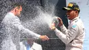 Pembalap Formula 1, Lewis Hamilton menyemprotkan sampanye usai menjuarai Grand Prix Formula 1 Silverstone di Inggris, (5/7/2015). Hamilton berhasil finish di urutan pertama dengan waktu 1 jam 31 menit 27,729 detik. (Reuters/Paul Childs)