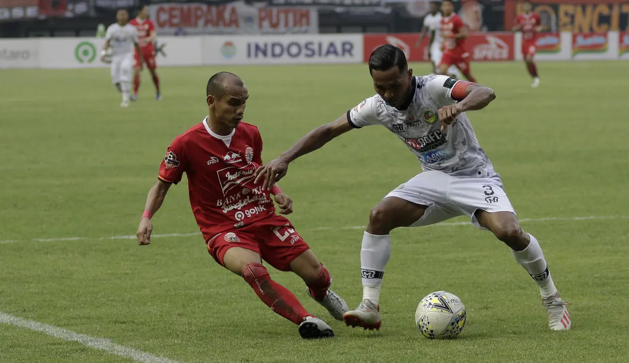 Gelandang Persija Jakarta, Riko Simanjutak, berebut bola dengan bek Tira Persikabo, Baduh Lestaluhu, pada laga Shopee Liga 1 di Stadion Patriot Chandrabhaga, Bekasi, Minggu (3/11). Persija menang 2-0 atas Tira Persikabo. (Bola.com/Yoppy Renato)