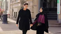 Matching pakai outfit warna hitam, Ria Ricis dan Teuku Ryan terlihat mesra berjalan bergandengan tangan. (Instagram/teukuryantr).