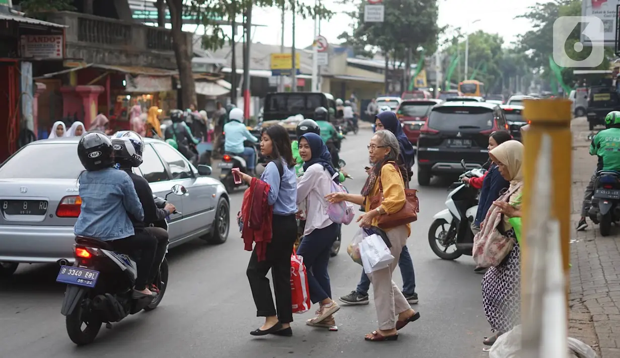 Pejalan kaki menyeberangi jalan di depan Stasiun Lenteng Agung, Jakarta, Senin (4/11/2019). Meski telah tersedia JPO, sebagian pejalan kaki lebih memilih untuk menyeberang sembarangan sehingga mengganggu arus lalu lintas serta berpotensi menimbulkan kecelakaan. (Liputan6.com/Immanuel Antonius)