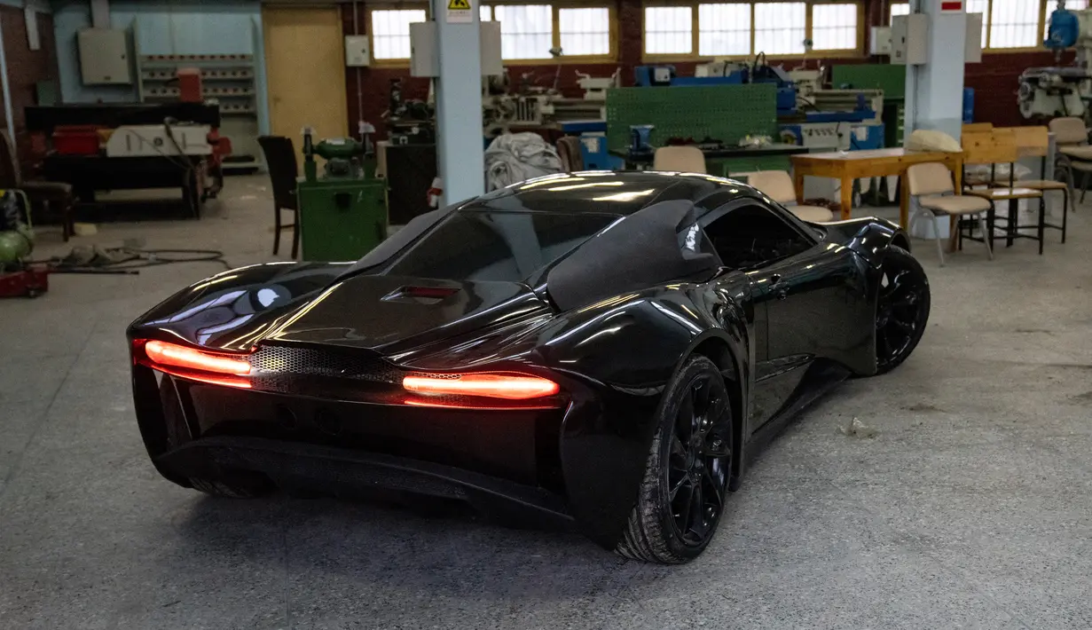 Mobil sport pertama buatan Afghanistan terlihat dalam studio mobil Entop di Kabul, Afghanistan, 13 Januari 2023. Beberapa hari lalu, mereka memutuskan untuk mengubah nama Mada 9 menjadi Black Swan karena dianggap mewakili kebanyakan sudut pandang dunia terhadap negara Afghanistan saat ini. (AP Photo/Ebrahim Noroozi)