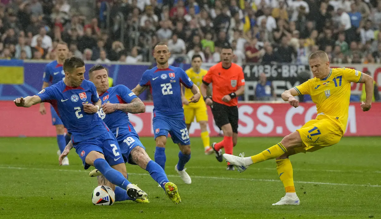 Bek Timnas Ukraina, Oleksandr Zinchenko (kanan) melepaskan tendangan dari dalam kotak penalti yang berusaha diblok dua pemain Timnas Slovakia, Juraj Kucka (tengah) dan Peter Pekarik pada laga matchday kedua Grup E Euro 2024 di Merkur Spiel-Arena, Dusseldorf, Jerman, Jumat (21/6/2024). (AP Photo/Martin Meissner)