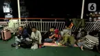 Aktivitas pemudik saat berada di kapal penyeberangan di Pelabuhan Ciwandan, Banten, Kamis (27/3/2025). (Liputan6.com/Herman Zakharia)