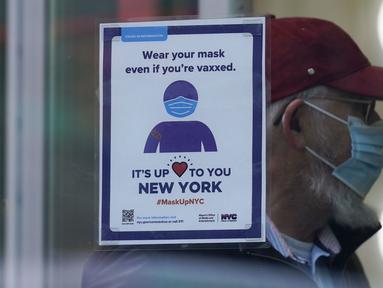 Sebuah tanda mengingatkan pelanggan bahwa masker diperlukan di toko mereka di New York, Senin (13/12/2021). Wajib masker di semua tempat umum dalam ruangan di negara bagian New York mulai berlaku pada Senin ketika para pejabat menghadapi lonjakan kasus COVID-19 dan rawat inap. (AP Photo/Seth Wenig)