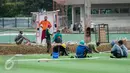 Pekerja menyelesaikan renovasi lapangan latihan timnas Indonesia di Kompleks Gelora Bung Karno, Senayan, Jakarta, Rabu (10/5). Pemerintah melakukan renovasi total kawasan Gelora Bung Karno guna menyambut Asian Games 2018. (Liputan6.com/Gempur M Surya)