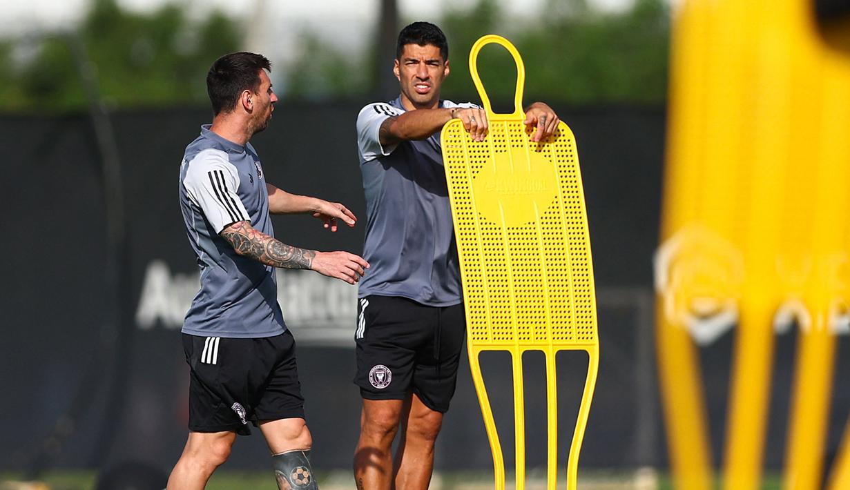 Pemain baru Inter Miami, Luis Suarez (kanan) berbincang dengan Lionel Messi ketika latihan pramusim Inter Miami di Florida Blue Training Center, dekat DRV PNK Stadium, Florida, Fort Lauderdale, Sabtu (13/01/2024) waktu setempat. (AFP/Getty Images/Megan Briggs)
