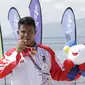 Atlet modern pentathlon, Muhammad Taufik, menunjukan medali usai meraih perunggu pada nomor beach triathle individual SEA Games 2019 di Subic, Jumat (6/12). Dirinya membukukan catatan waktu 00:17:37.76.  (Bola.com/M Iqbal Ichsan)